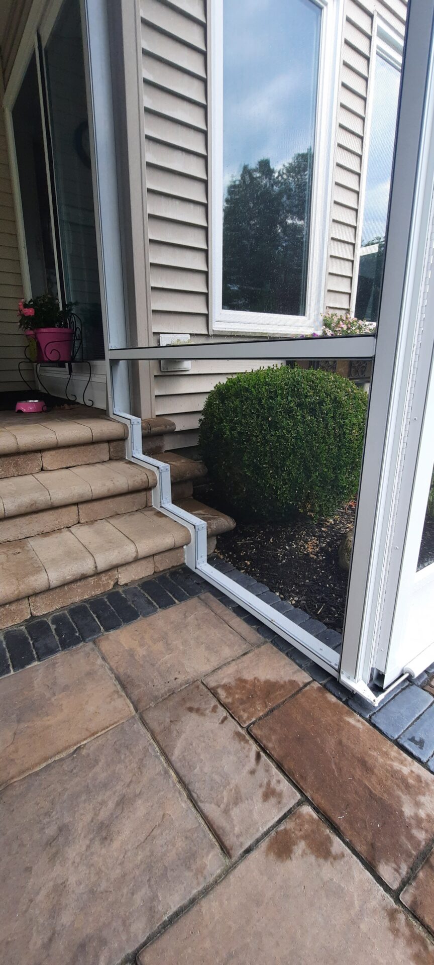 Screening Solutions Ohio uses custom permanent screening to enclose an outdoor patio in Northeast Ohio. The custom screen frame is recessed and shaped around the stone steps.