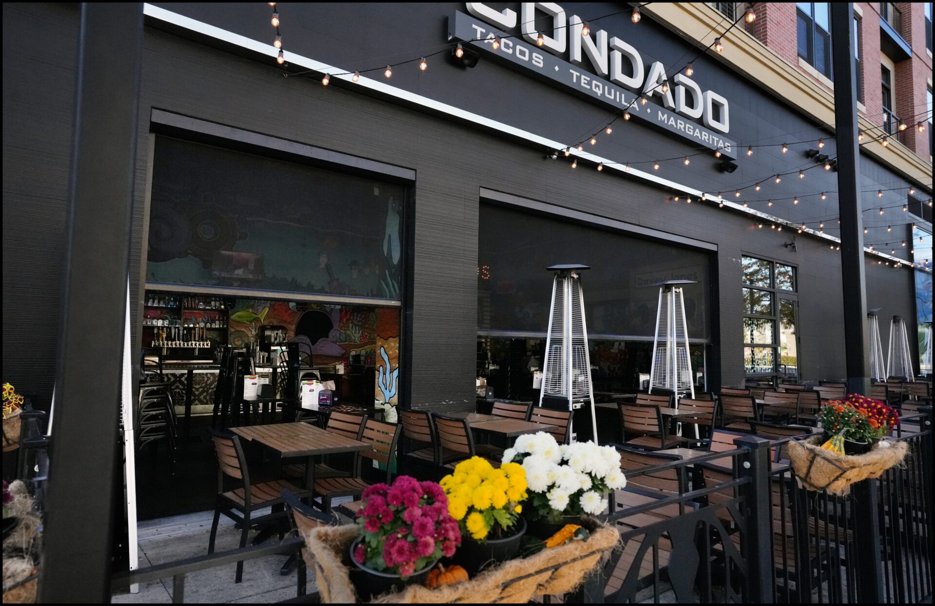 Condado Tacos is a popular local taco joint located right inside of Crocker Park. Screening Solutions Ohio installed Phantom Retractable Power Screens onto the restaurants two large garage openings. The motorized screens provide bug protection in a matter of seconds. With the touch of a button, the screens drop down and seal in the space. Whenever the screens aren’t needed, they roll up and hide away inside their protective housing units blending in with the look of the building.