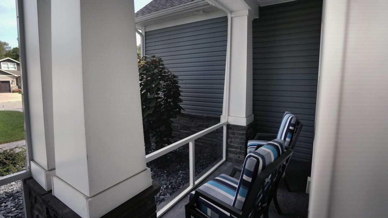 Screening Solutions Ohio installed fixed permanent porch screens to enclose this Port Clinton, Ohio home’s front porch and back patio to keep out insects. The custom screens are splined in with custom shaped framing to enclose and seal unique openings. The porches use a combination of insect and solar mesh to achieve both full insect protection and sun block in both of the outdoor spaces.