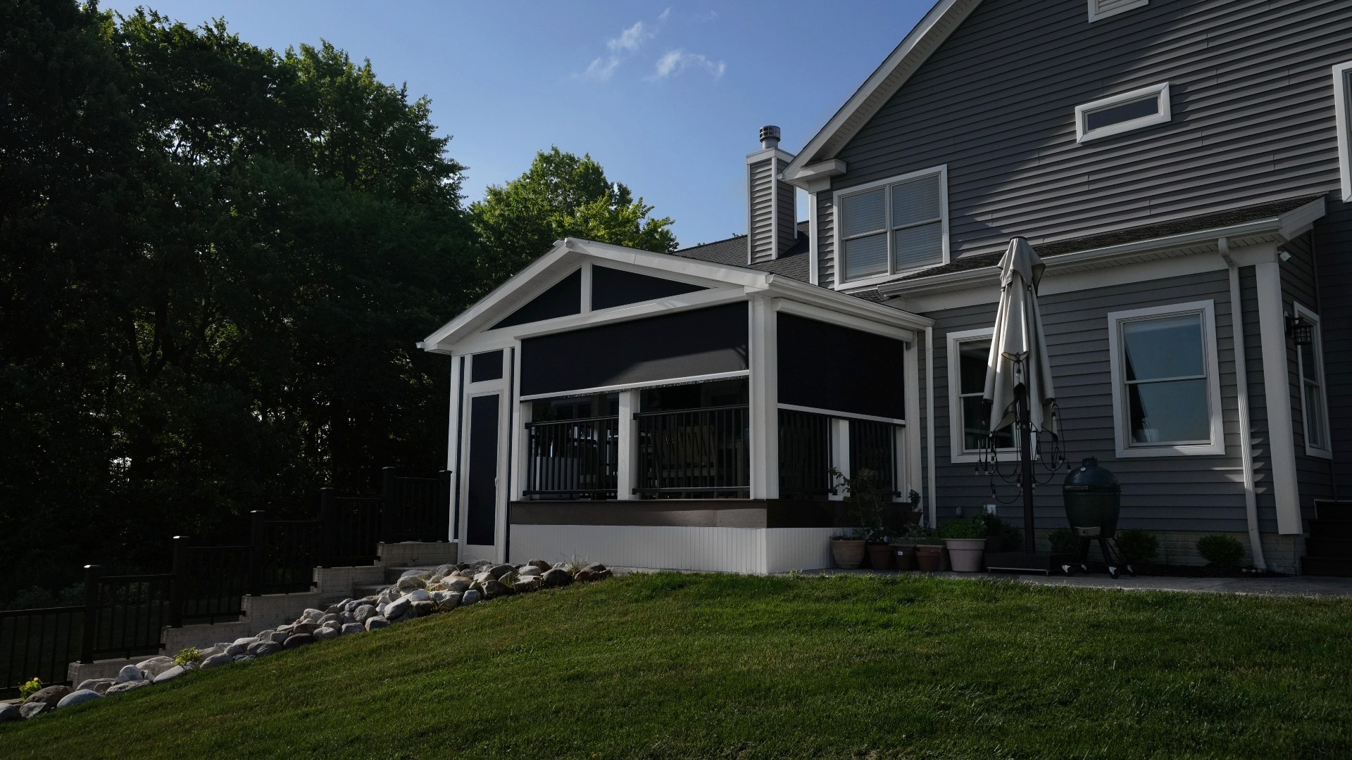 Screening Solutions transformed this covered patio in Brecksville by installing custom Phantom Motorized Screens to the main three openings and then used custom fixed screening for the uniquely shaped openings and peak.